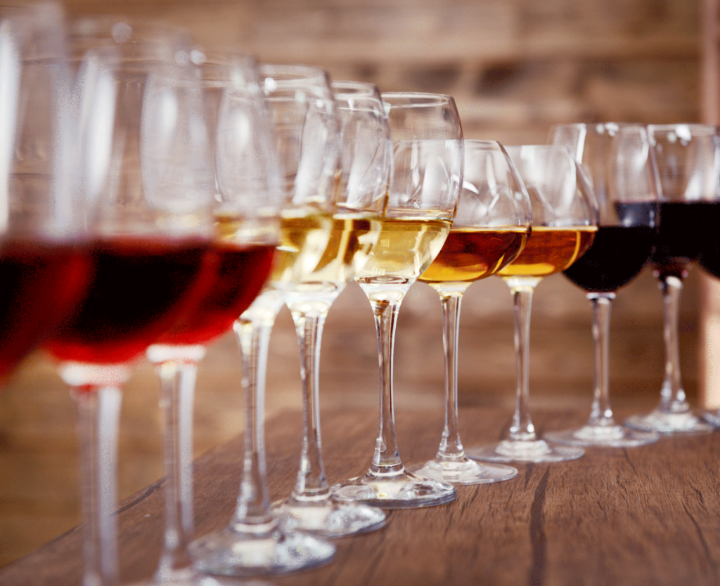 variety of wines in glasses on wooden table